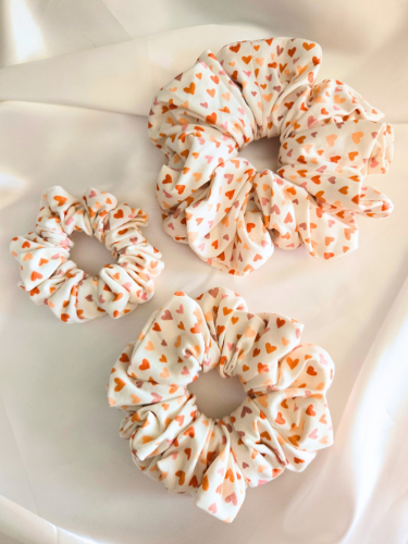 Witte scrunchie met hartjes in drie verschillende maten: Mini (links), Medium (onder), Maxi (boven)