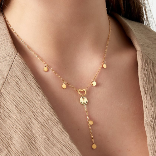 Goudkleurige y-vormige ketting met coins en een hartje gedragen om de hals