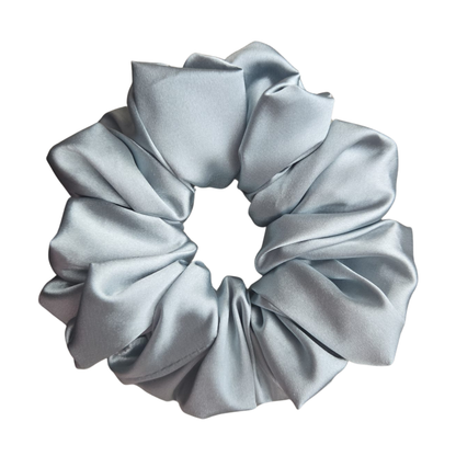 Handgemaakte blauwgroene Arctic Satin Scrunchie met grijze ondertoon van glanzende satijnen stof op een neutrale achtergrond