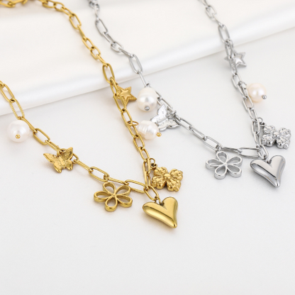 Set van twee schakelkettingen in goud en zilver met hart-, bloem-, vlinder- en parelbedels – stijlvolle sieradenset voor dames.