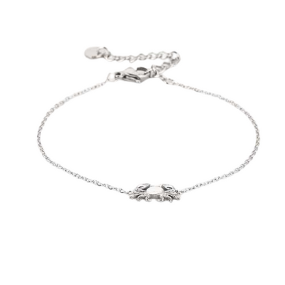 Liggende dunne zilverkleurige RVS armband met minimalistisch krabbedel, subtiele beachlook.