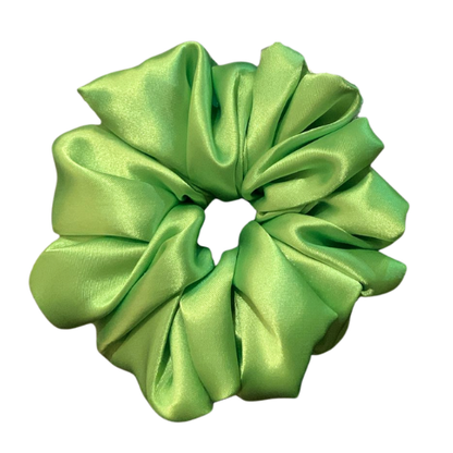 Handgemaakte heldergroene Lime satin scrunchie van glanzende satijnen stof op een neutrale achtergrond