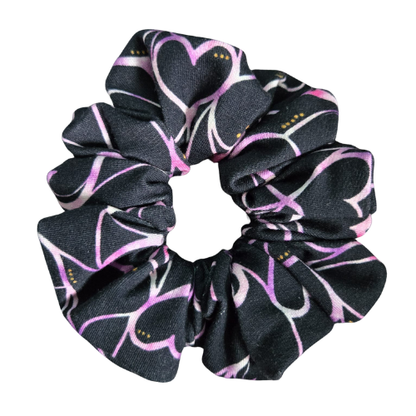 Handgemaakte katoenen scrunchie met paarse hartjesprint op een zwarte achtergrond, stevige grip voor het haar