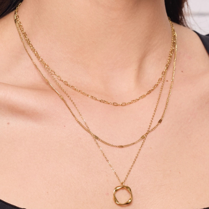 Goudkleurige, drielaagse ketting met een mooie cirkelvormige hanger gedragen om de hals