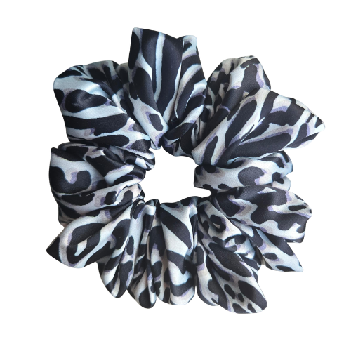 Handgemaakte Safari Satin Scrunchie van zwart-wit satijn met zebraprint en luipaardprint op een lichte achtergrond
