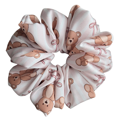 Luxe handgemaakte satijnen scrunchie met teddybeertjes en roze strikjes op een wit en lichtroze gestreepte achtergrond, glanzende stof die pluis en klitten in het haar vermindert
